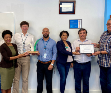 Six employees of Curaçao National Airport holding a sustainability award
